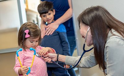 pediatrician doctor Leong checking toddler's heart beat