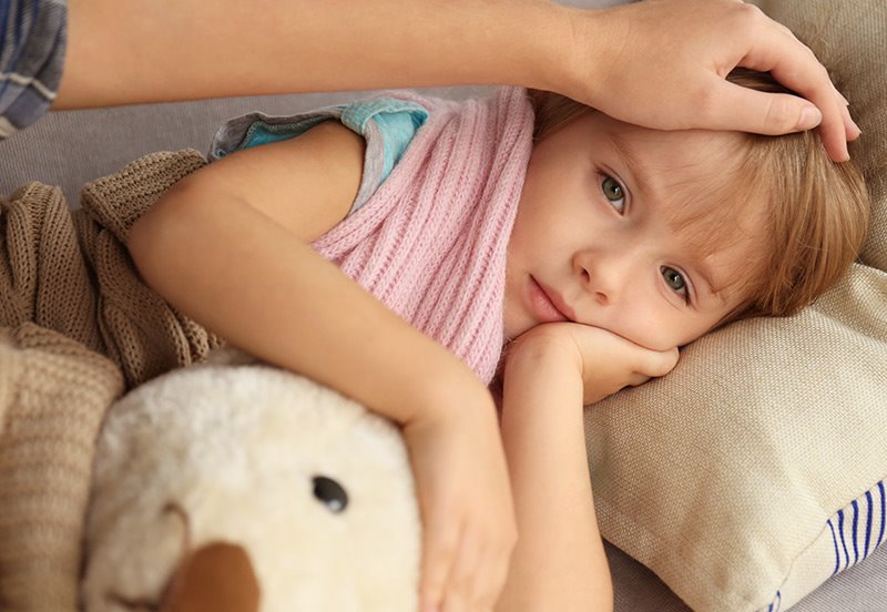 giving cold medicine to a sick child