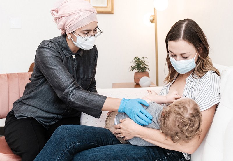 Lactation consultant teaching a woman how to breastfeed