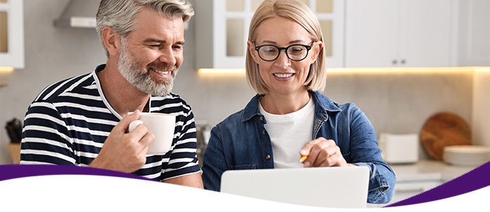 Adult couple updating their medical insurance information online using their laptop device'