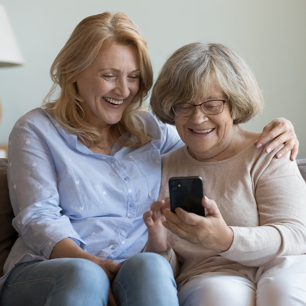Adult daughter and senior mother requesting adult proxy access to an ARC MyChart account using a mobile device while on a couch at home