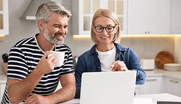 Adult couple updating their medical insurance information online using their laptop device