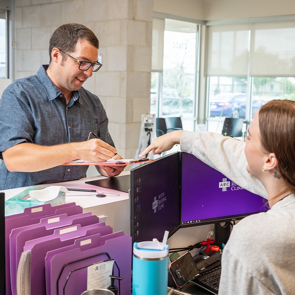 Image of an adult ARC patient checking in at an ARC clinic front desk