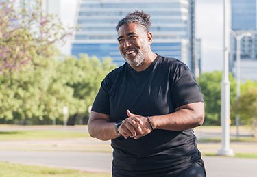 ARC patient enjoying a walk at the park with the Austin skyline in the background