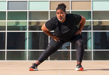 ARC patient stretching before enjoying a walk/run in Austin, and a building in the background