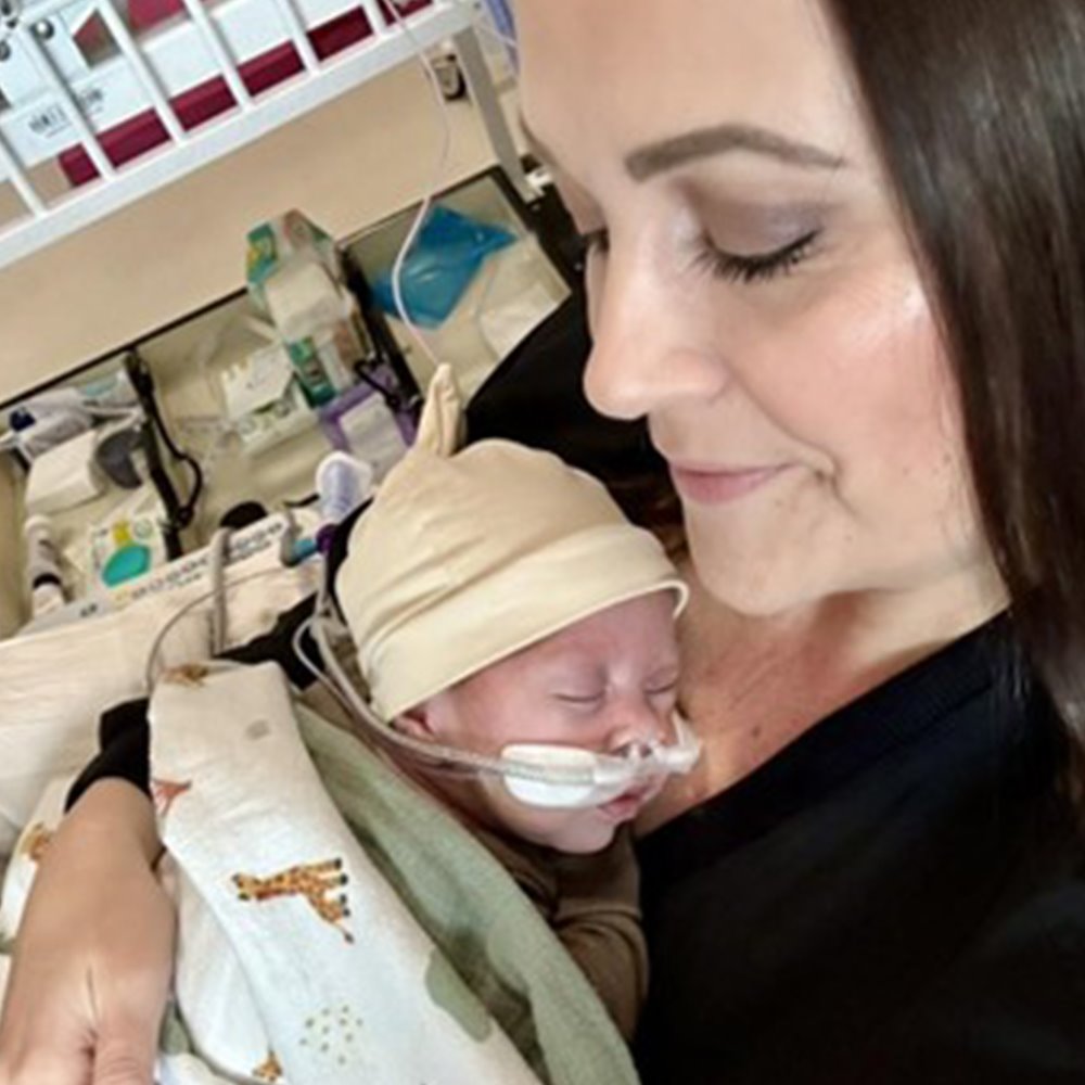 Mom holding her infant son in a hospital/clinic setting