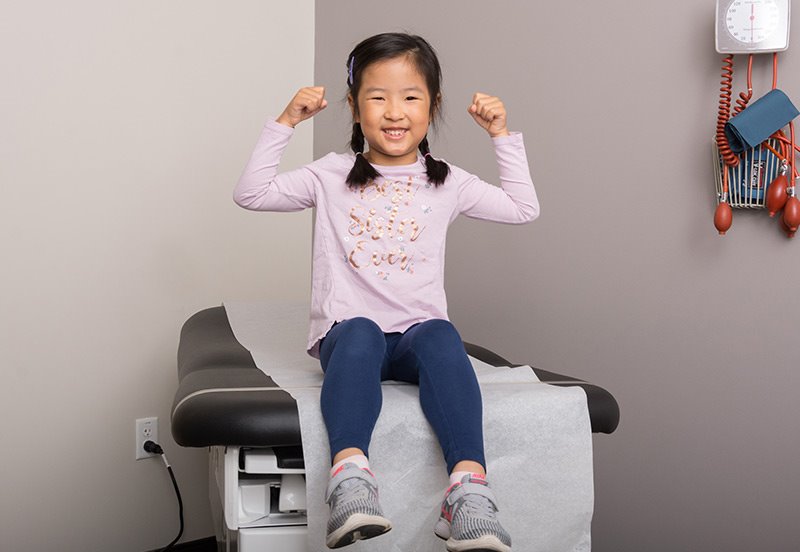 little girl flexing after receiving her Covid-19 shot