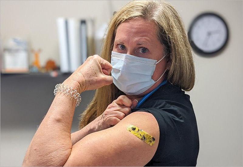 woman flexing after getting vaccinated for Covid-19
