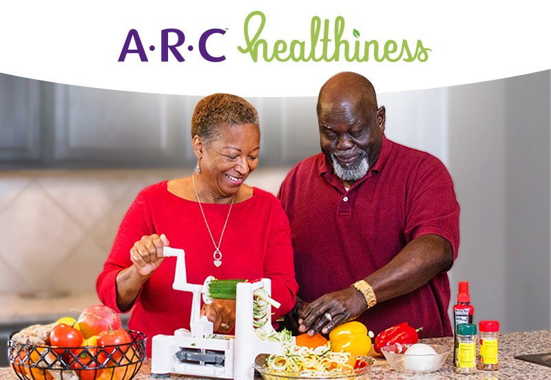 Older couple preparing a healthy meal in their kitchen and the ARC Healthiness Program logo
