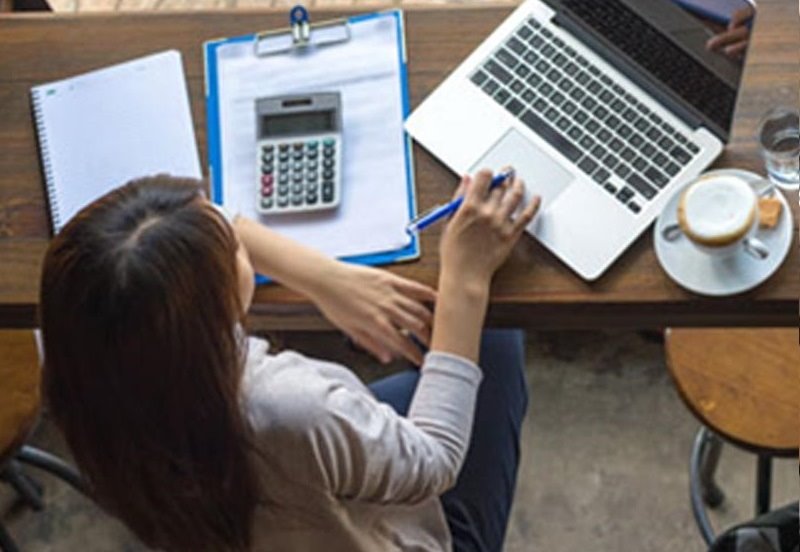 Woman Drinking coffee while using the computer to book an appointment