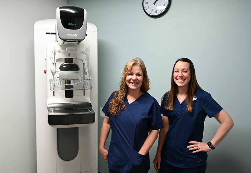 Two ARC mammography technicians next to a mammography machine at ARC