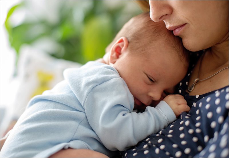 mom with post partum depression hugging her infant
