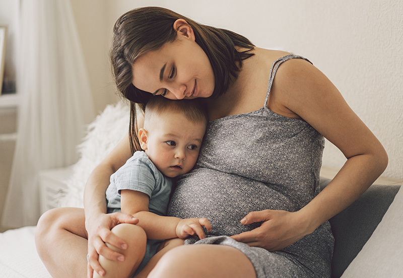 Pregnant mother hugging her child