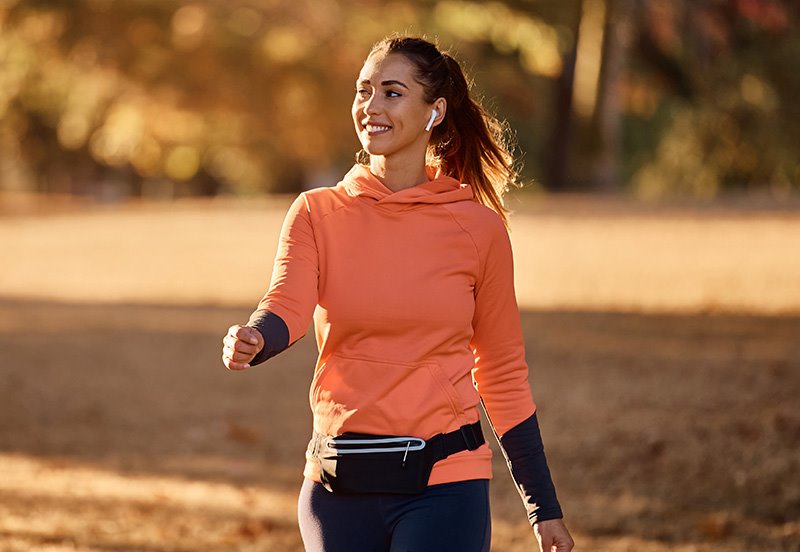Woman enjoying a walk outside during the fall, representing management of multiple sclerosis (MS)